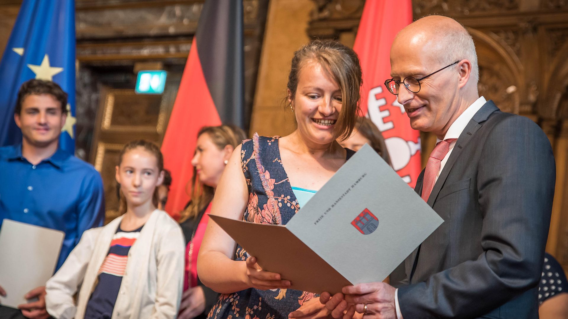 Hamburgs Erster Bürgermeister übergibt eine Einbürgerungsurkunde