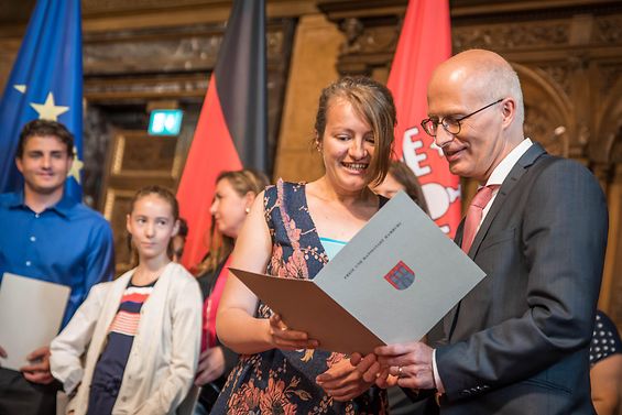 Hamburgs Erster Bürgermeister übergibt eine Einbürgerungsurkunde